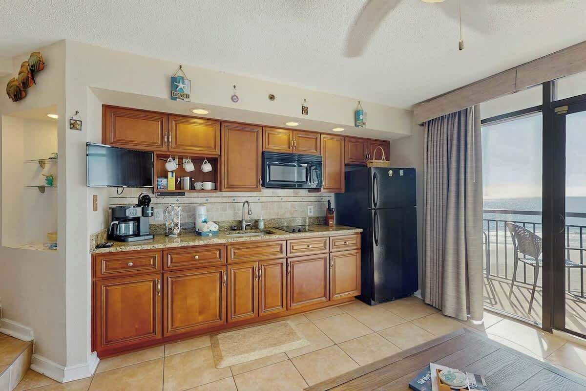 Una cocina moderna con armarios de madera, microondas y refrigerador.