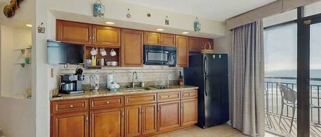 Una cocina moderna con armarios de madera, microondas y refrigerador.