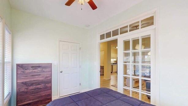 A bedroom with a bed, a dresser, a closet with glass doors, and a ceiling fan. - Savannah Shores Unit 12 (Myrtle Beach)