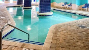 An indoor swimming pool with tiled walls and a clear pool area. - This is It 2 BR Condo (North Myrtle Beach)