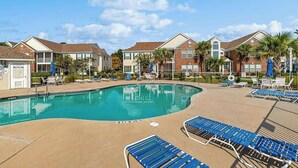 A pool area with lounge chairs and a lifeguard stand. - Sterling Pointe 120-A at Wachesaw III (Murrells Inlet)