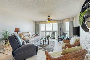Ein geräumiges Wohnzimmer mit einer Sofagarnitur, einem Couchtisch und einem Fernseher.