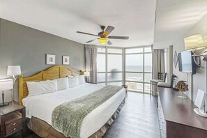 A hotel room with a bed, a desk, a television, and a window with a view. - Sunrise Tides at the Cherry Grove Pier (North Myrtle Beach)