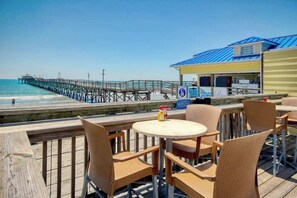 A beachside restaurant with outdoor seating overlooking the ocean. - Sunrise Tides at the Cherry Grove Pier (North Myrtle Beach)