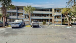 Un hotel a più piani con un parcheggio di fronte.