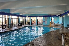 Ein Innenpool mit klarem Wasser, umgeben von blauen Wänden und einem gefliesten Boden.
