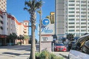 A hotel sign with palm trees and a clear sky. - Coastal Living Retreat (Myrtle Beach)
