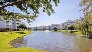 A residential area with a pond, buildings, and a fountain. - Luster Leaf Unit 303 (Myrtle Beach)