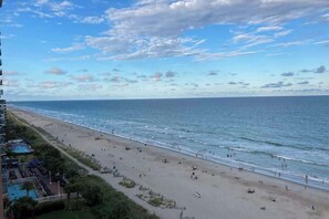 A beach with a pool area and a view of the ocean. - Sandcastle South 1102 (Myrtle Beach)