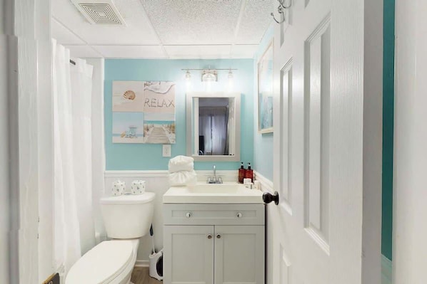 Een badkamer met toilet, wastafel en kast.