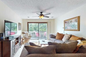 A living room with a sofa, television, and ceiling fan. - Shipwatch Pointe II  P-302 (Myrtle Beach)