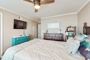 A bedroom with a bed, a ceiling fan, a television, a dresser, and a window. - Summer Place Unit B-4 (North Myrtle Beach)