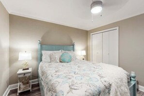 Une chambre à coucher avec un lit, des tables de chevet, une lampe et une armoire.