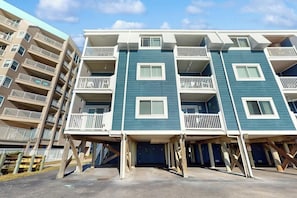 A multi-story residential building with balconies, a central entrance, and a parking area. - Summer Place Unit B-4 (North Myrtle Beach)