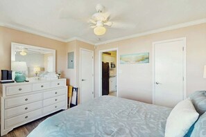 Ein Schlafzimmer mit einem Bett, einem Schminktisch und einem Deckenventilator.