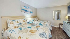 Ein Schlafzimmer mit einem Bett, Nachttischen, einer Kommode, einem Spiegel und einem Wandbild.