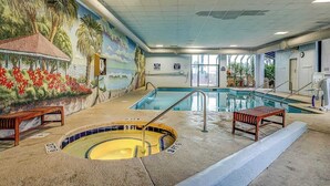 Ein Hallenbad mit Wandmalerei, Whirlpool und Sitzbank.