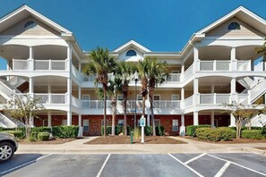A multi-story hotel with balconies, palm trees, and a parking lot. - Ironwood - Turtle Beach (North Myrtle Beach)