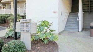Une entrée d’immeuble avec une plaque indiquant les numéros d’appartements 2118 à 2426.