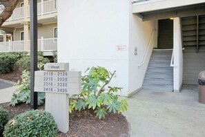A building entrance with a sign indicating apartment numbers 2118-2426. - Sand Angels at Ocean Creek (Myrtle Beach)