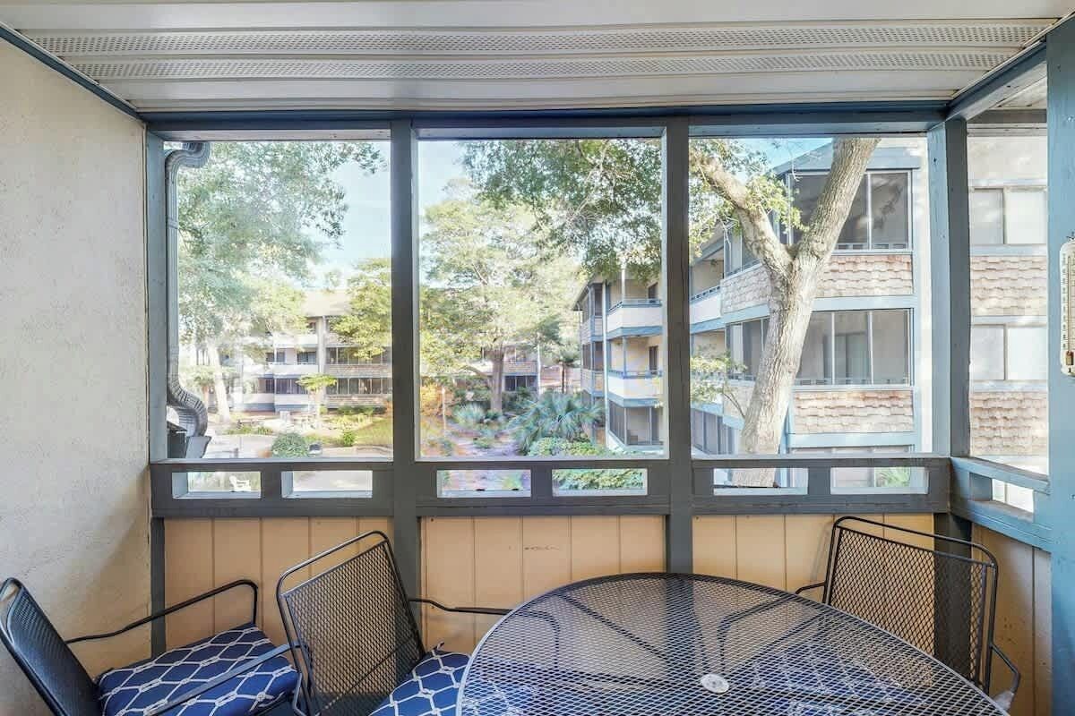 Ein Zimmer mit großem Fenster, einem runden Tisch und zwei Stühlen.