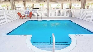 A 3-foot deep shallow pool with a lifeguard sign, white deck, and chairs. - Coconut Grove Unit 202 (North Myrtle Beach)