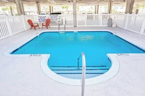 A 3-foot deep shallow pool with a lifeguard sign, white deck, and chairs. - Coconut Grove Unit 202 (North Myrtle Beach)