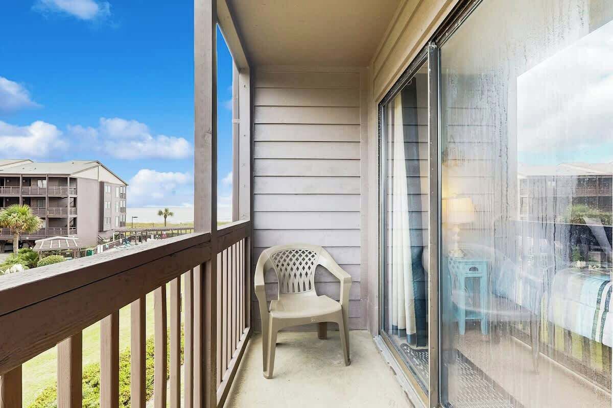 A balcony with a view of a building and a chair.
