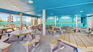 An indoor dining area with wooden picnic tables and blue walls. - Renaissance Tower 1114 (Myrtle Beach)