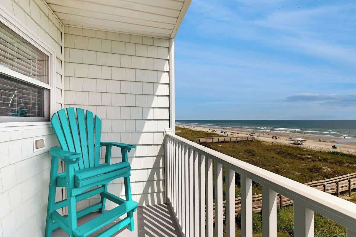 Een balkon met uitzicht op het strand en de oceaan.