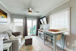 A compact living space with a sofa, ottoman, dining table, and a ceiling fan. - Breathtaking Beach Views (North Myrtle Beach)
