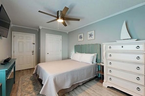 A bedroom with a bed, dresser, ceiling fan, and a sailboat decoration. - Breathtaking Beach Views (North Myrtle Beach)