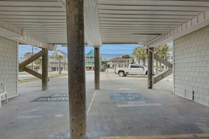 A covered outdoor area with a concrete floor, a bench, and a building entrance. - Breathtaking Beach Views (North Myrtle Beach)