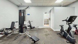 A gym with exercise equipment including a bench press, a leg press, and an elliptical machine. - Renaissance Tower 816C (Myrtle Beach)