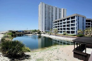 Ein Hotel mit mehreren Etagen, einem Pool und Strand.