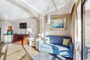 A modern living room with a sofa, a television, a cabinet, and a painting on the wall. - Seaside Luxe | Caravelle Two Oh Six (Myrtle Beach)