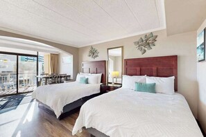 A hotel room with two beds, a balcony with a table and chairs, and a large window. - Caravelle Resort 206 (Myrtle Beach)
