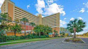 A multi-story hotel with a flat roof, a central courtyard, and a sign indicating it is a Courtyard hotel. - Caravelle Resort 206 (Myrtle Beach)