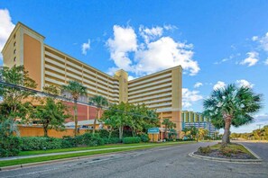 A multi-story hotel with a flat roof, a central courtyard, and a sign indicating it is a Courtyard hotel. - Caravelle Resort 206 (Myrtle Beach)