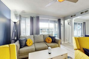 Un salon moderne avec un canapé, une table basse et une lampe.
