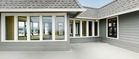 Un bâtiment à l’extérieur gris, doté de grandes fenêtres et d’un toit plat.