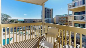 A balcony with a view of a swimming pool and adjacent buildings. - Ocean Bridge Unit 4-B19 (Myrtle Beach)