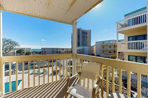 A balcony with a view of a swimming pool and adjacent buildings. - Ocean Bridge Unit 4-B19 (Myrtle Beach)