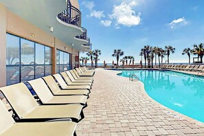 A poolside area with lounge chairs and a clear view of the ocean. - Grande Cayman Unit 1057 (Myrtle Beach)