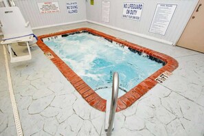 Ein Whirlpool mit Sicherheitswarnungen und Poolregeln an den Wänden.