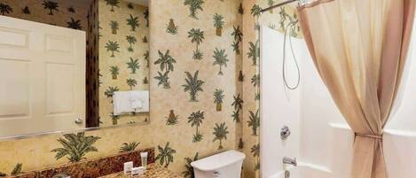 A bathroom with a sink, toilet, and shower curtain.