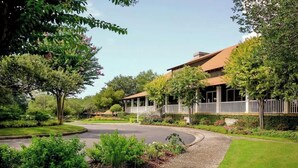 A residential property with a curved driveway, a covered porch, and a well-maintained garden. - North Tower Unit 301 (North Myrtle Beach)
