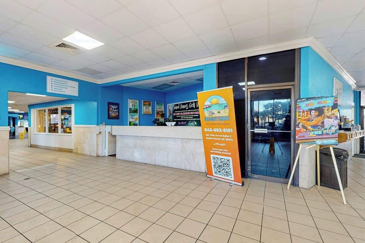 A reception area with a blue and white color scheme, a counter, and a sign with a QR code.