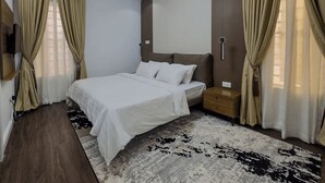 Een moderne hotelkamer met een groot bed, een nachtkastje en een tv aan de muur.