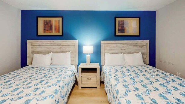 A double room with two beds, a nightstand between them, and a ceiling fan. - Tilghman Beach and Golf 1519 (North Myrtle Beach)